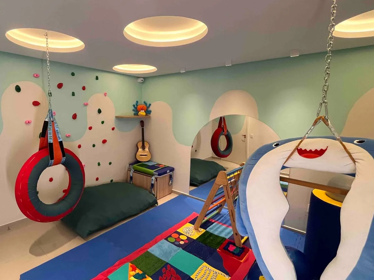 Sala sensorial com parede de escalada e balanços