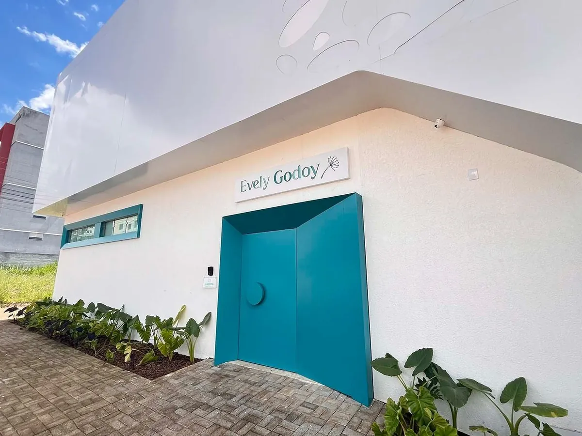 Entrada da clínica, com a porta azul e a placa Evely Godoy